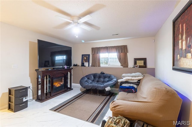 16910 Lawrence Dr, Saint Robert, MO 65584 - living area featuring ceiling fan, a lit fireplace, a textured ceiling, and marble finish flooring