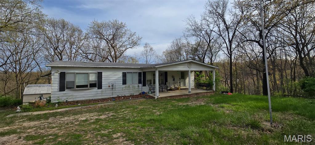 4598 Schenk Rd, Barnhart, MO 63012 - view of front of house featuring a porch and a front yard
