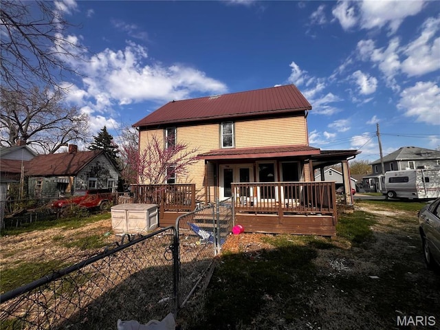 rear view of property with metal roof and a porch