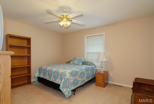 bedroom with light colored carpet, baseboards, and ceiling fan