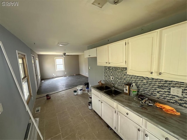 2370 Hawthorne Manor Dr, Florissant, MO 63031 - kitchen featuring a sink, decorative backsplash, open floor plan, and white cabinets