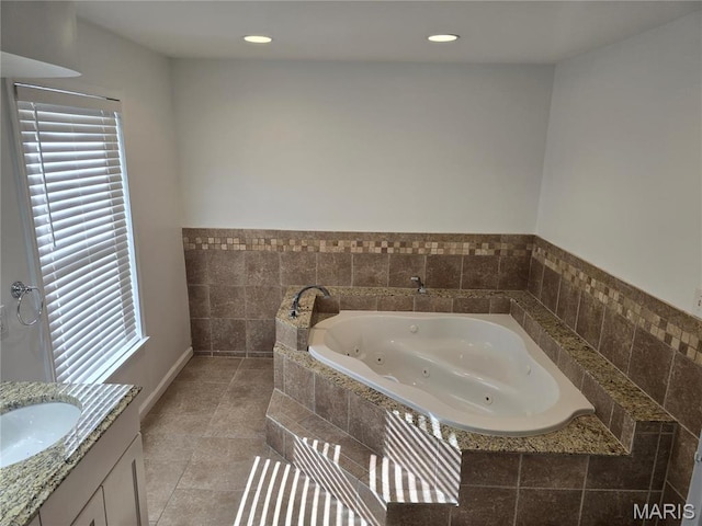bathroom with a tub with jets, vanity, tile patterned floors, and recessed lighting