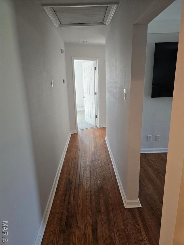corridor with attic access, wood finished floors, and baseboards
