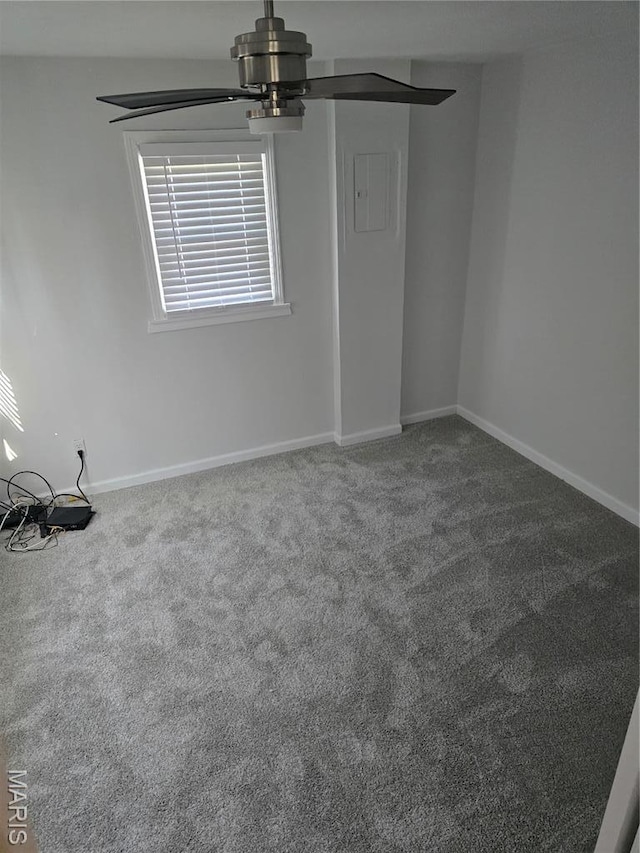 carpeted empty room with a ceiling fan and baseboards