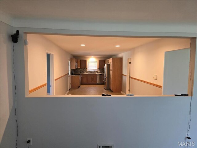 kitchen featuring stainless steel appliances, brown cabinetry, recessed lighting, and decorative backsplash
