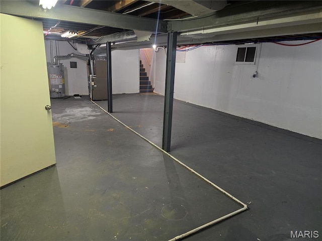 unfinished below grade area featuring gas water heater, stairs, and heating unit