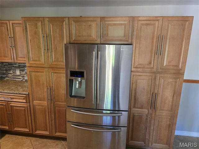 kitchen featuring stainless steel fridge with ice dispenser, light stone countertops, light tile patterned flooring, tasteful backsplash, and brown cabinetry