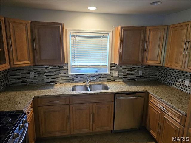 kitchen with stainless steel appliances, a sink, decorative backsplash, light stone countertops, and light tile patterned flooring