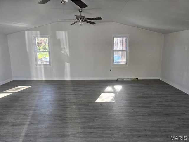 empty room with lofted ceiling, healthy amount of natural light, baseboards, and wood finished floors