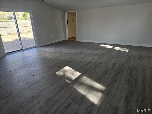 unfurnished living room featuring dark wood-style floors and baseboards