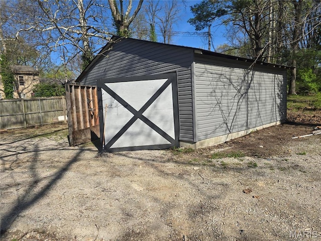 view of outdoor structure featuring fence and an outdoor structure