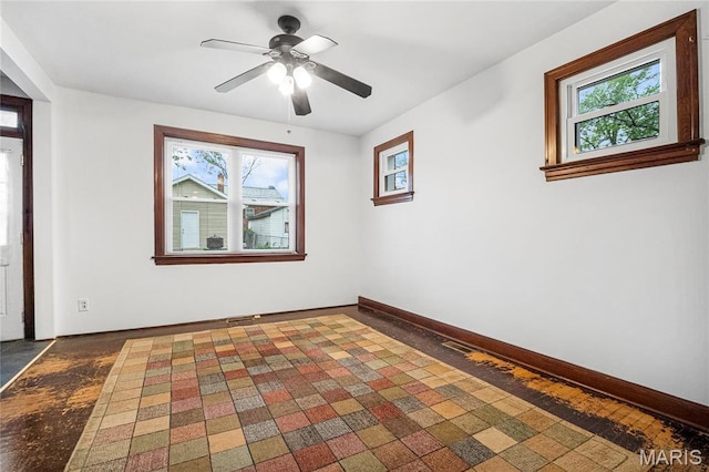 unfurnished room with healthy amount of natural light, baseboards, and a ceiling fan