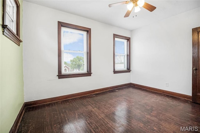 empty room featuring wood finished floors, a ceiling fan, and baseboards