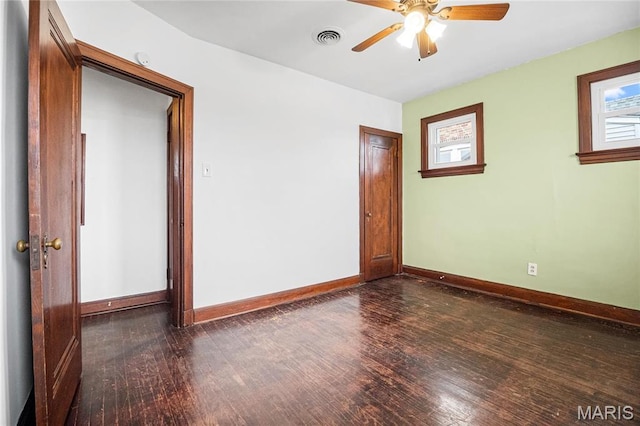 unfurnished room with dark wood-style flooring, baseboards, and a ceiling fan