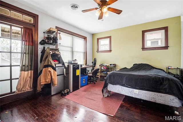 bedroom featuring hardwood / wood-style flooring, multiple windows, and a ceiling fan