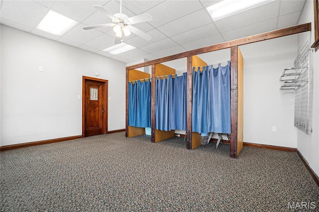 misc room featuring carpet flooring, ceiling fan, baseboards, and a drop ceiling