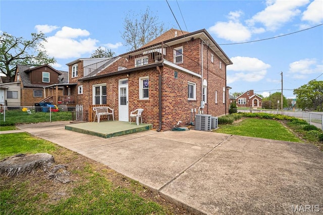 back of property featuring a patio, brick siding, and central AC