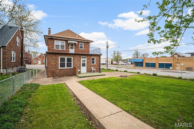 view of front of home featuring brick siding, a chimney, and a balcony