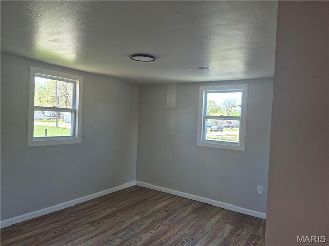 2205 Miracle Ave, Granite City, IL 62040 - unfurnished room featuring dark wood-type flooring, baseboards, and a textured ceiling