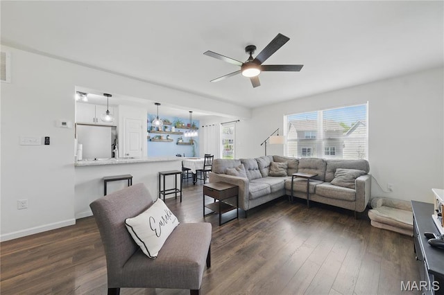 living room featuring a ceiling fan, dark wood-type flooring, and baseboards
