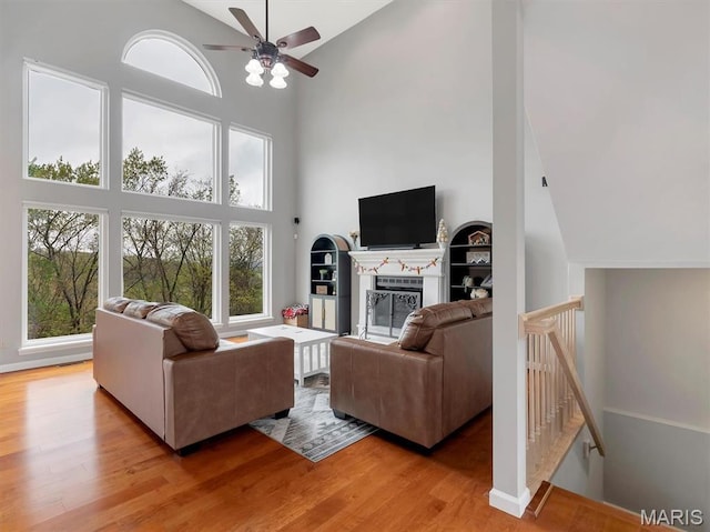 535 Vista Hills Ct, Eureka, MO 63025 - living room featuring high vaulted ceiling, ceiling fan, light wood-type flooring, a glass covered fireplace, and baseboards