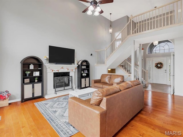 535 Vista Hills Ct, Eureka, MO 63025 - living area featuring a towering ceiling, stairway, wood finished floors, ceiling fan, and built in shelves