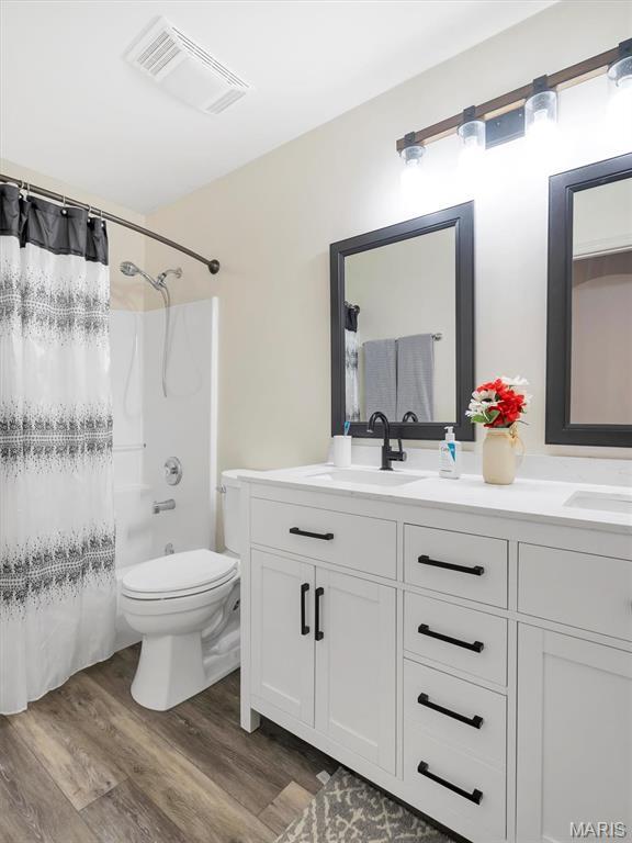 535 Vista Hills Ct, Eureka, MO 63025 - full bathroom featuring wood finished floors, double vanity, and toilet