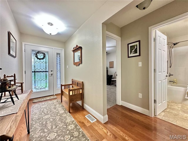 foyer entrance with light wood-style floors and baseboards
