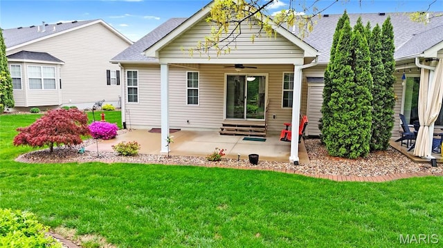 rear view of property featuring a ceiling fan, a patio, a yard, and a shingled roof