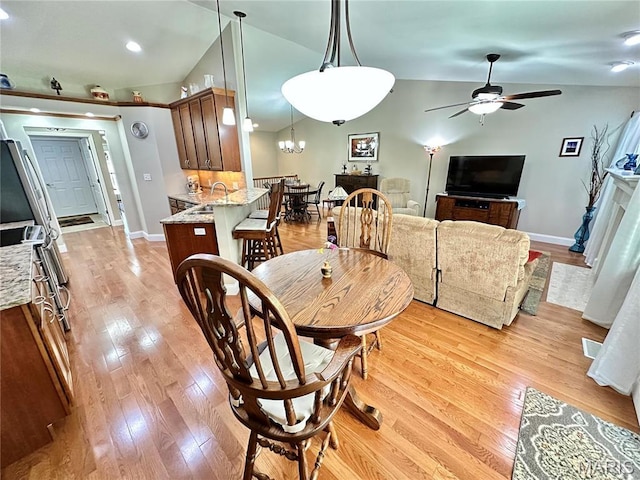 dining area featuring vaulted ceiling, ceiling fan, light wood finished floors, baseboards, and recessed lighting