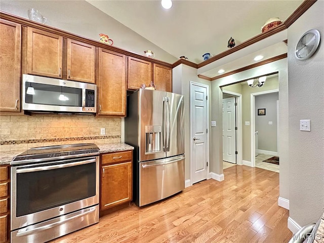 kitchen featuring appliances with stainless steel finishes, tasteful backsplash, light wood-style floors, vaulted ceiling, and crown molding