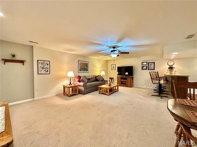 carpeted living room with baseboards, a bar, and ceiling fan