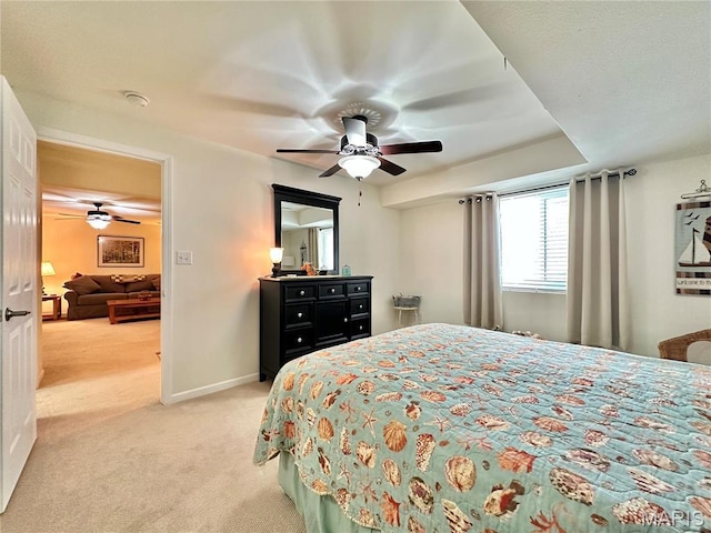 bedroom featuring light colored carpet, a ceiling fan, and baseboards