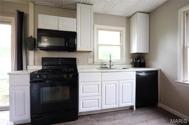 90 La Sierra Dr, Florissant, MO 63031 - kitchen featuring black appliances, a sink, white cabinetry, and healthy amount of natural light