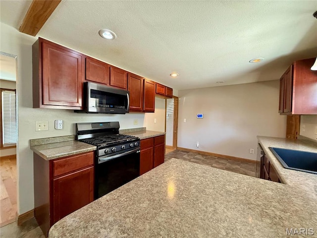 kitchen with stainless steel microwave, range with gas cooktop, baseboards, light countertops, and recessed lighting