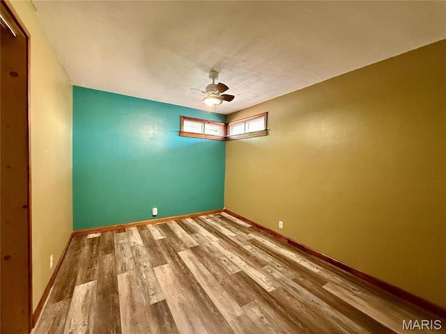 empty room with wood finished floors, ceiling fan, and baseboards