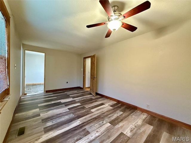 spare room with wood finished floors, baseboards, and ceiling fan