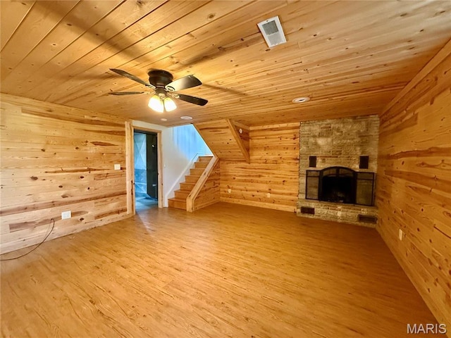 additional living space featuring wood walls, wood ceiling, wood finished floors, ceiling fan, and a fireplace