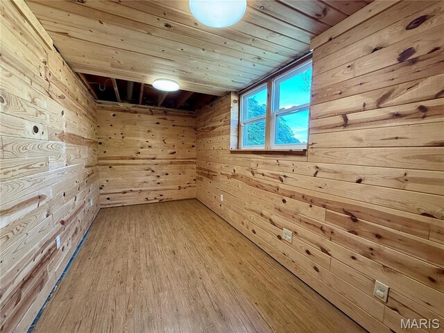 unfurnished room with wooden ceiling, wooden walls, and wood finished floors