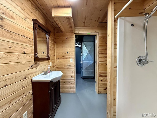bathroom featuring a shower, wooden walls, concrete floors, vanity, and wooden ceiling
