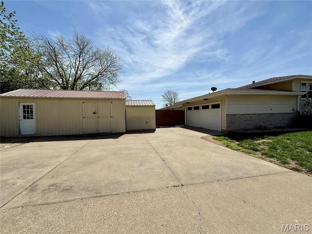 garage featuring concrete driveway and a storage unit