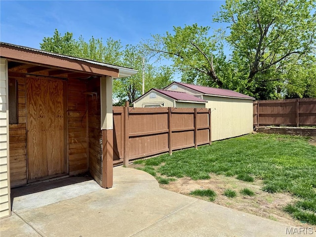 view of yard featuring a shed, an outdoor structure, and a patio