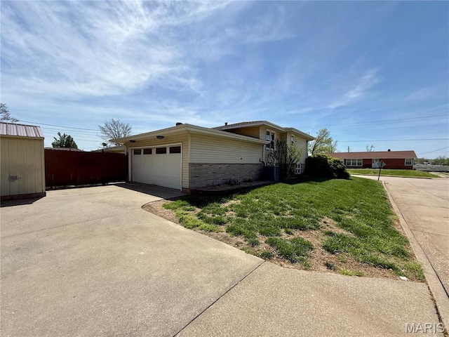 view of side of property with driveway and a garage