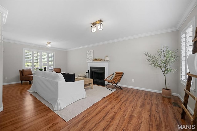 35 Heatherwood Ct, Ofallon, MO 63368 - living area featuring wood finished floors, a fireplace with flush hearth, and crown molding