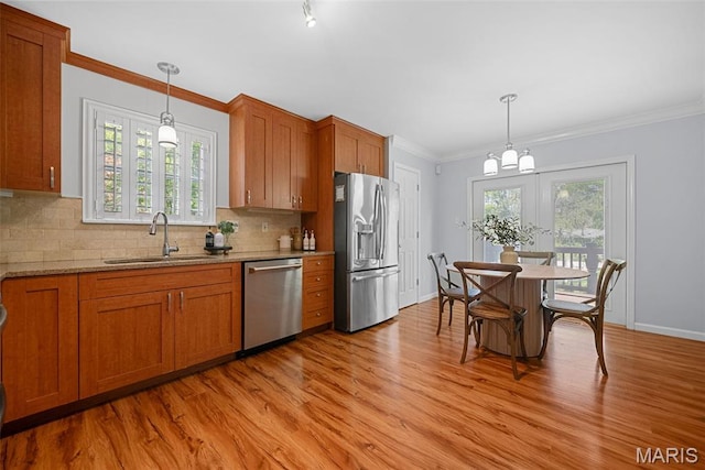 35 Heatherwood Ct, Ofallon, MO 63368 - kitchen with appliances with stainless steel finishes, brown cabinets, light wood-type flooring, plenty of natural light, and crown molding
