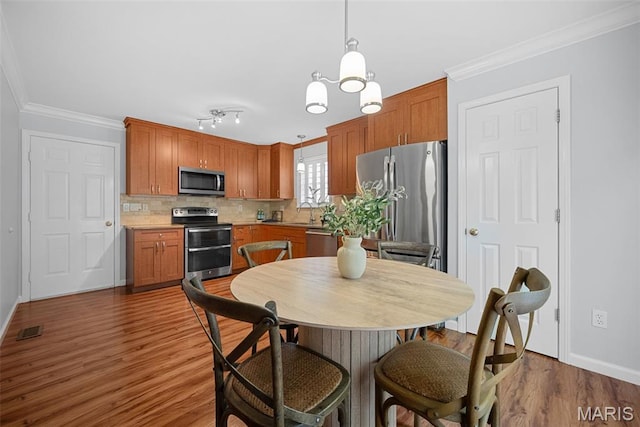 35 Heatherwood Ct, Ofallon, MO 63368 - dining area with wood finished floors, crown molding, and a chandelier