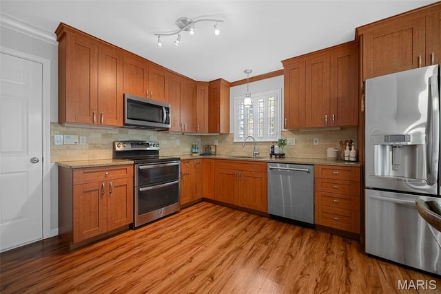 35 Heatherwood Ct, Ofallon, MO 63368 - kitchen featuring appliances with stainless steel finishes, crown molding, light wood-type flooring, and tasteful backsplash