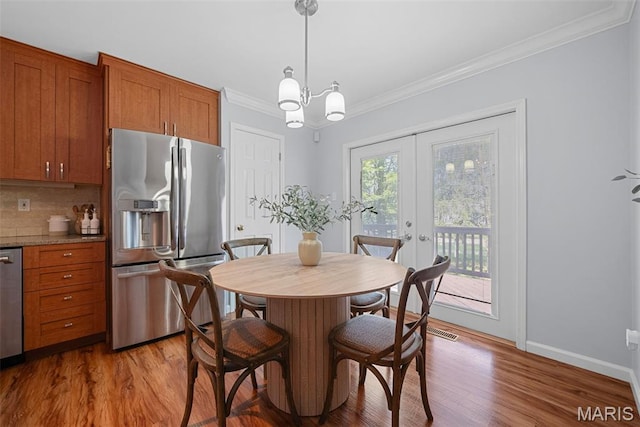 35 Heatherwood Ct, Ofallon, MO 63368 - dining area with crown molding, light wood-style floors, a chandelier, and french doors