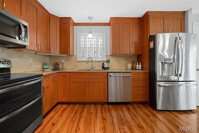 35 Heatherwood Ct, Ofallon, MO 63368 - kitchen featuring stainless steel appliances, light wood-type flooring, brown cabinetry, light stone counters, and crown molding