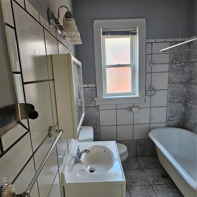 6336 Laura Ave, Saint Louis, MO 63136 - full bath with toilet, tile walls, a soaking tub, vanity, and tile patterned floors